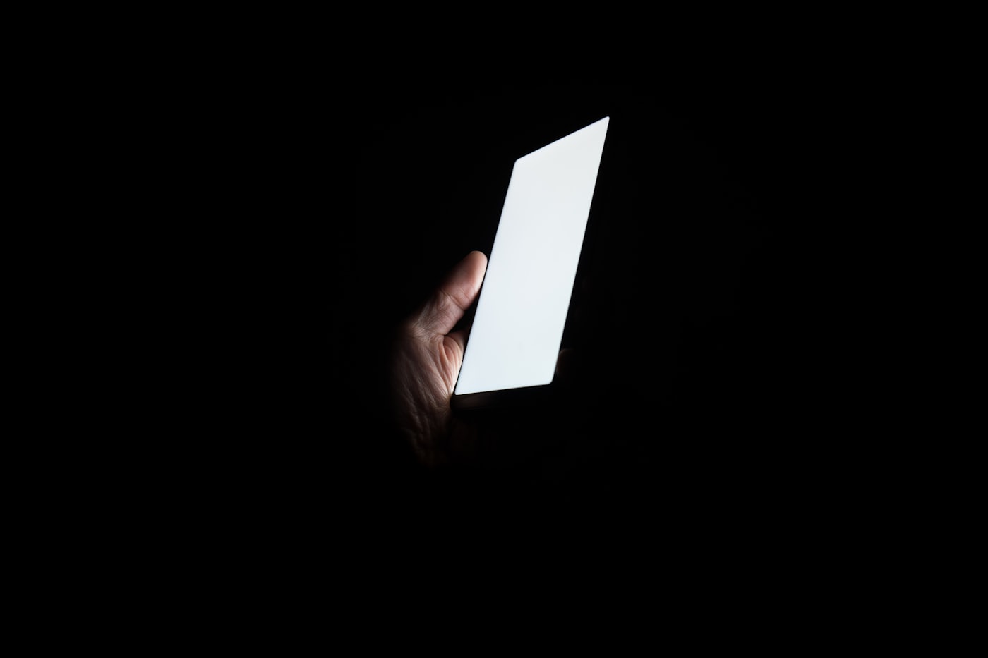 Person holding a glowing smartphone at night